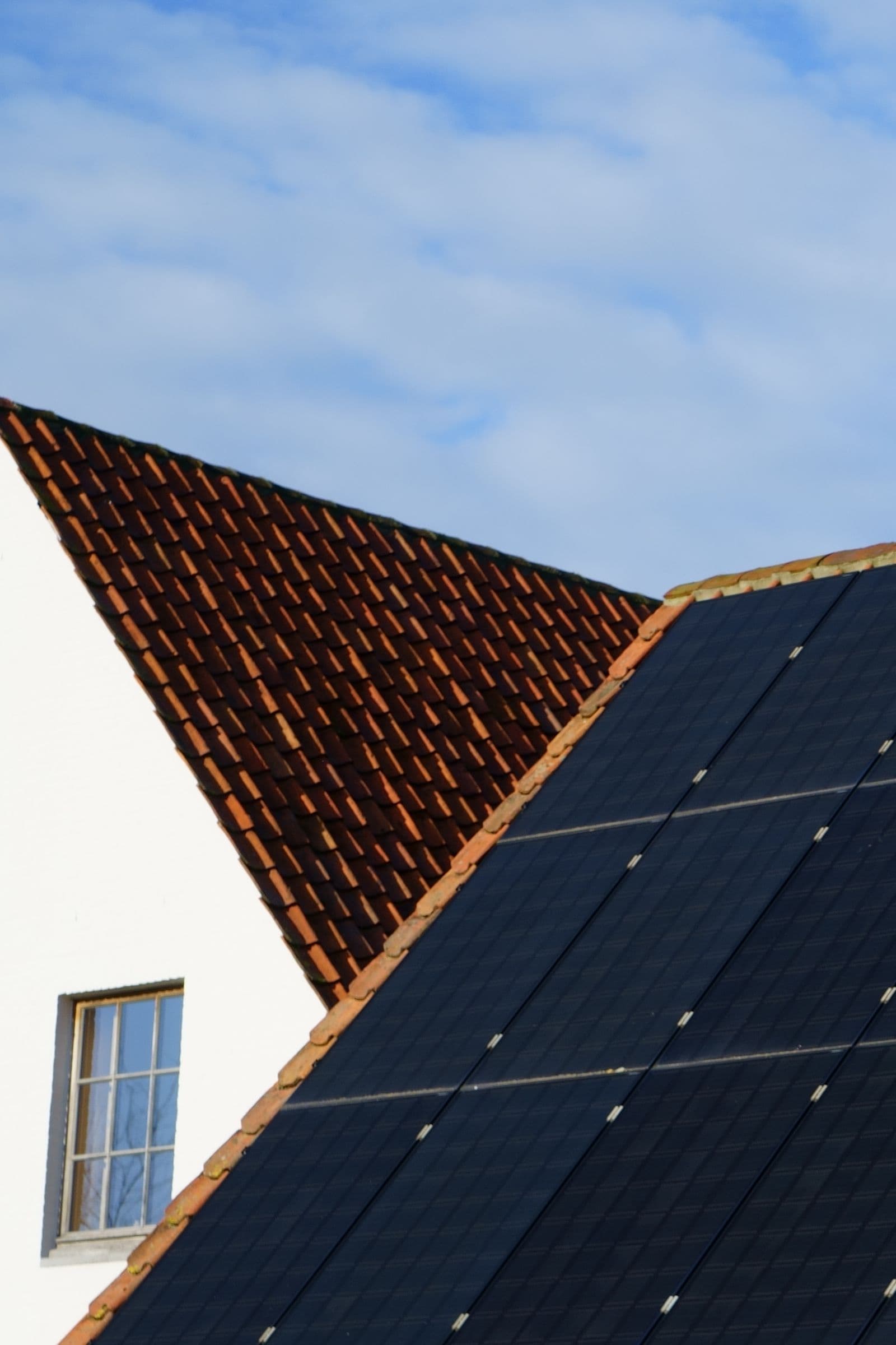 Módulos fotovoltaicos em telhado de telhas vermelhas